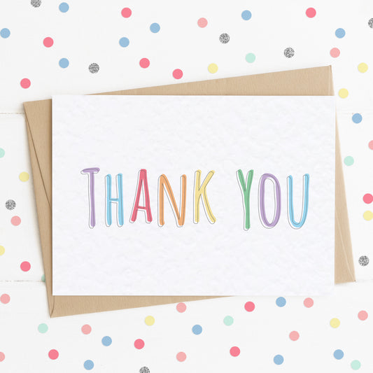 A vibrant thank you card with a colourful rainbow message saying "Thank You".