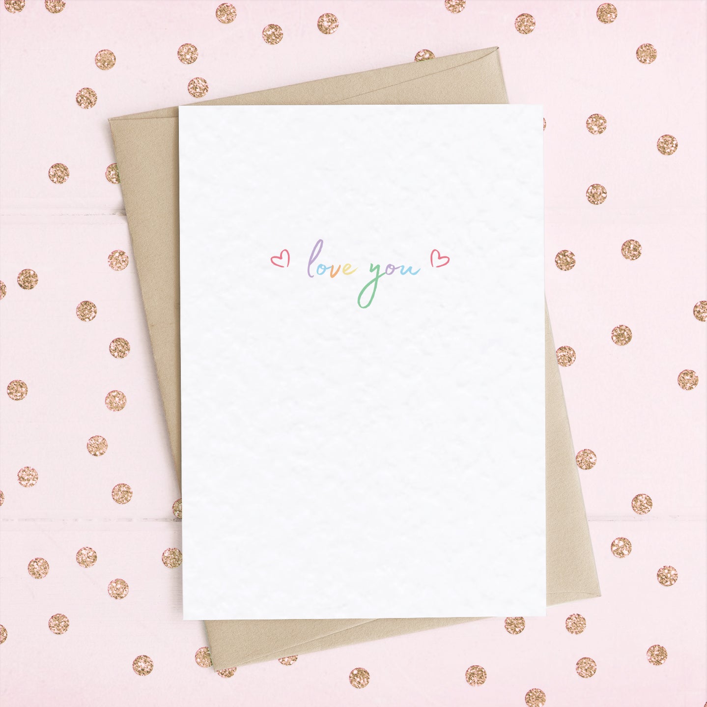 A cute A6 love card with the message "Love You" in colourful rainbow type, with two reds hearts either side.