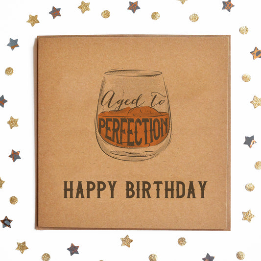 A funny Retro Birthday Day Card with the message "Happy Birthday" and a whisky glass illustration with "Aged To Perfection" inside.