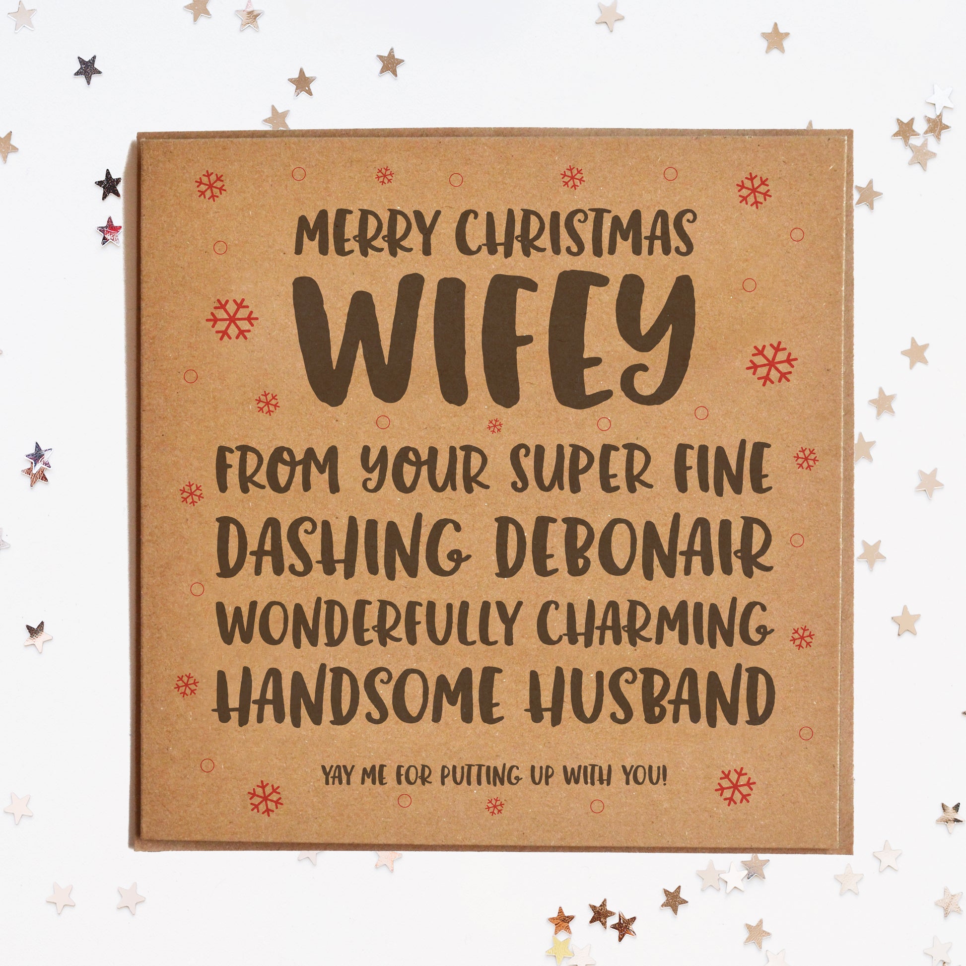 A funny Christmas card for the wife, in festive colours and a message saying "MERRY CHRISTMAS WIFEY! FROM YOU FINE, DASHING DEBONAIR, WONDERFULLY CHARMING HANDSOME HUSBAND! YAY ME FOR PUTTING UP WITH YOU!"