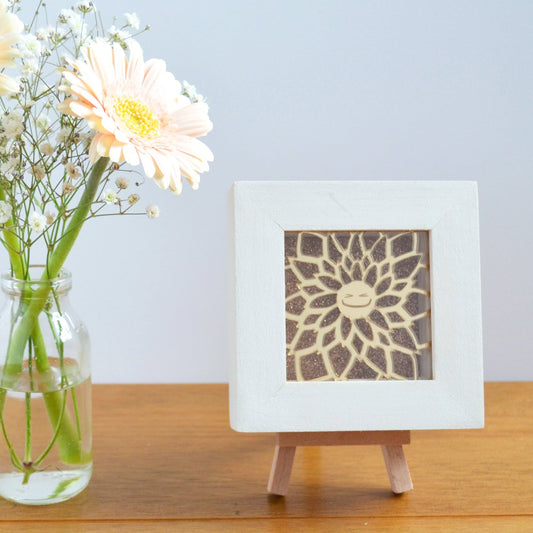 A cute gold mirror acrylic laser cut smiling happy flower, with a gold glitter background, in a rustic white wooden box frame. This design is Ginny Gerbera.