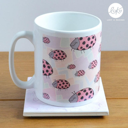 A cute and colourful ladybird ceramic mug/cup, with a happy smiling ladybird pattern on a rainbow background design.  Dishwasher and microwave safe.