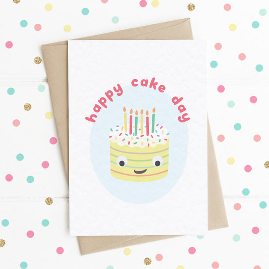 A funny celebration card with a happy smiling cake illustration and the message, "HAPPY CAKE DAY".