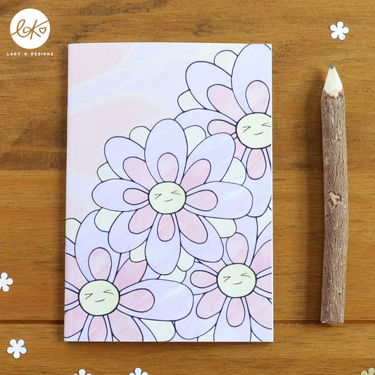 A cute A6 size notebook with a smiling happy flower design. The characters name is Daisy Doo.