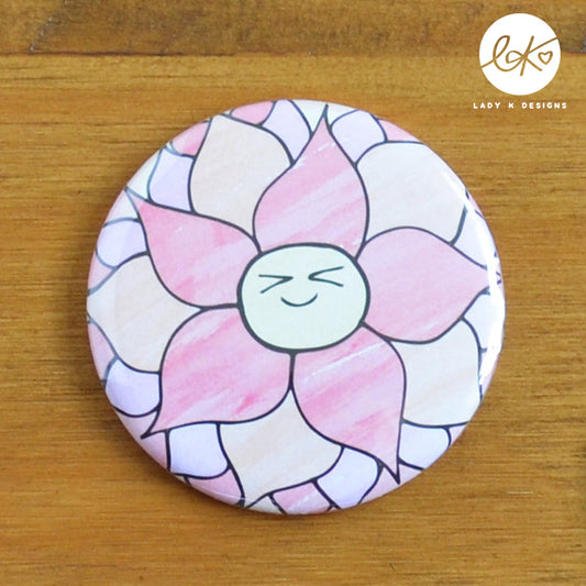 A cute 58mm Pocket Mirror with a smiling happy flower design. The characters name is Dorothy Dahlia.