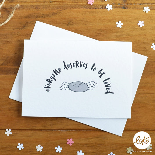 An A6 size card, with a cute smiling happy spider design, with the message "Everyone Deserves To Be Loved".