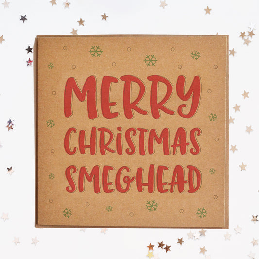 A funny Christmas card in festive colours and the message "Merry Christmas Smeghead" surrounded by decorative snowflakes.