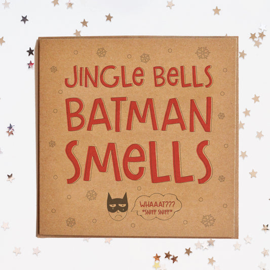  A funny Christmas card in festive colours and the message "Jingle Bells, Batman Smells" and a sad Batman illustration underneath saying "Whaaat! Sniff! Sniff!".