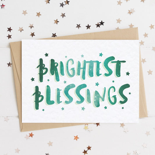 A celestial Christmas card with a stars and text in colours inspired by the northern lights/hygge and the message, "BRIGHTEST BLESSINGS".