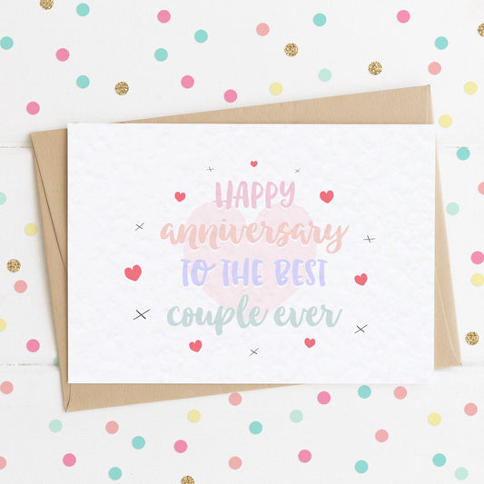 A cute anniversary card with a colourful pastel message saying "Happy Anniversary To The Best Couple Ever" surrounded by complimenting hearts and x kisses.
