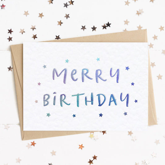 A fun birthday card with a stars and text in colours inspired by the northern lights/universe and the message, "Merry Birthday".