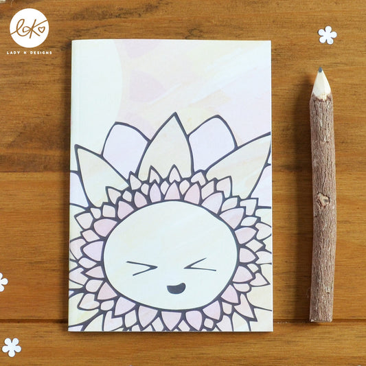 A cute A6 size notebook with a smiling happy flower design. The characters name is Sunny.