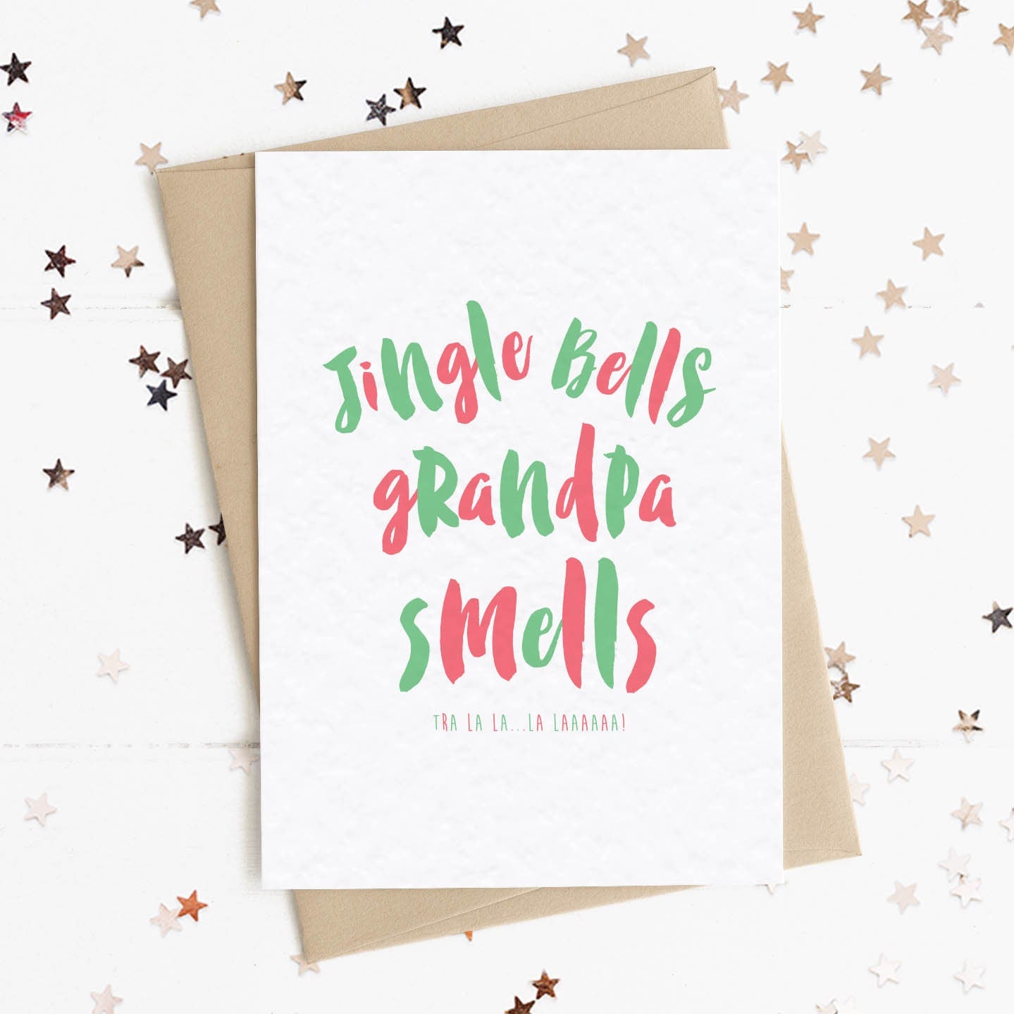 A funny Christmas card in festive colours and the message "Jingle Bells Grandpa Smells".